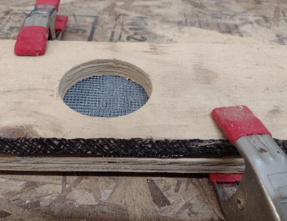 Hardware cloth stack clamped between boards. 